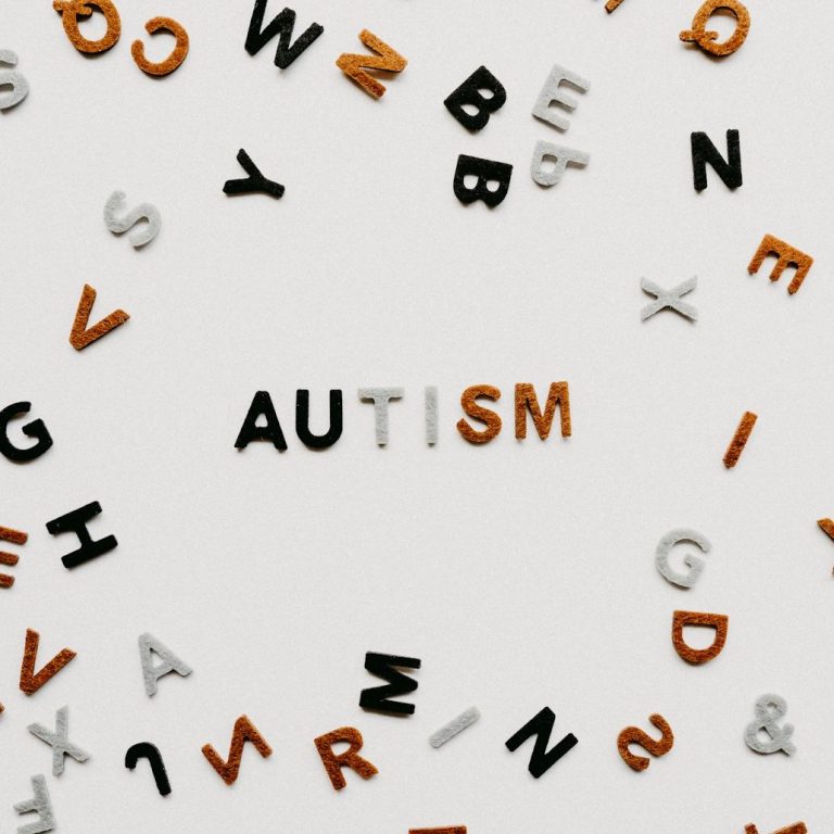 The word "AUTISM" stands out among scattered alphabet letters.